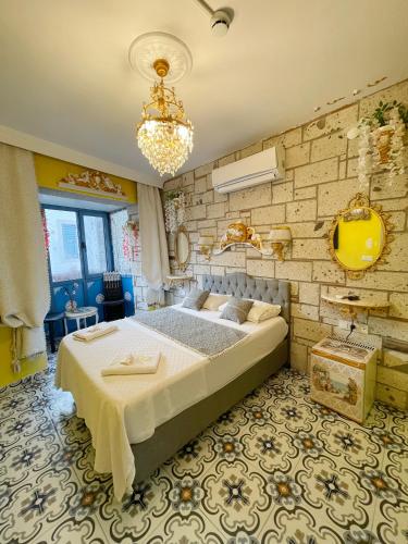 a bedroom with a large bed and a brick wall at Lamur Hotel in Alaçatı
