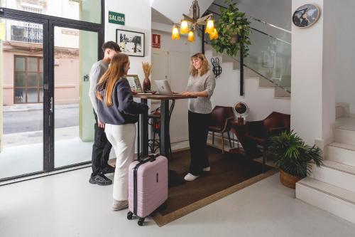 a group of people standing around a table with a suitcase at Zalamera BnB in Valencia
