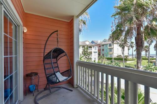 a chair on a porch with a view of the ocean at Dawn 824-Sea n Swim in Galveston