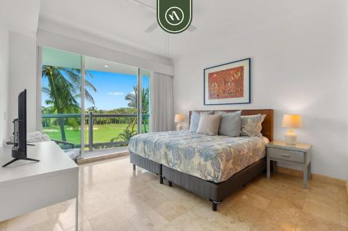 a bedroom with a bed and a tv and a balcony at New 2BR/2BA Nuevo Vallarta Condo | Pool, Beach in Nuevo Vallarta