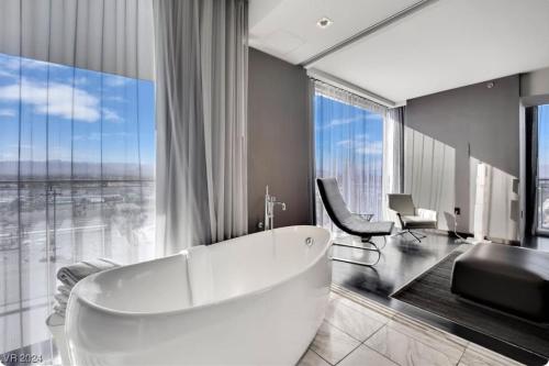a bathroom with a white tub and a large window at Palms Place in Las Vegas