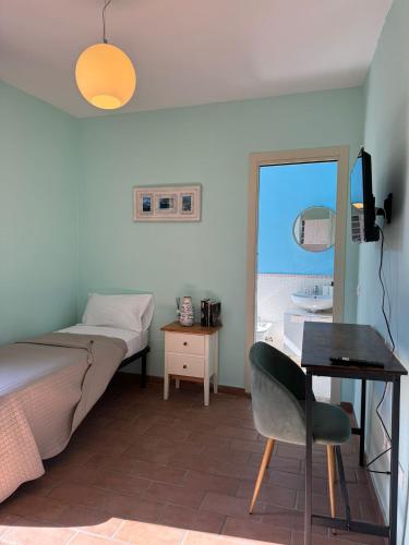 a bedroom with a bed and a desk and a window at La casa sui tetti di Varzi in Varzi