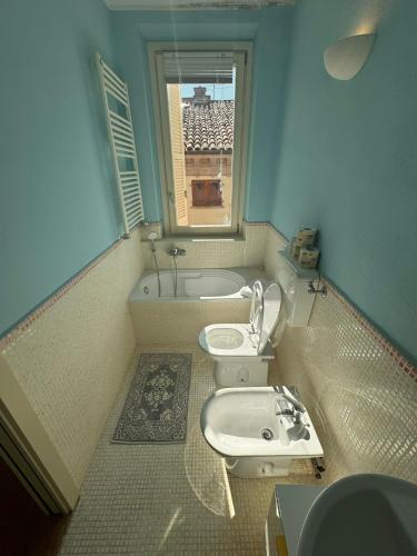 a bathroom with a sink and a toilet and a window at La casa sui tetti di Varzi in Varzi