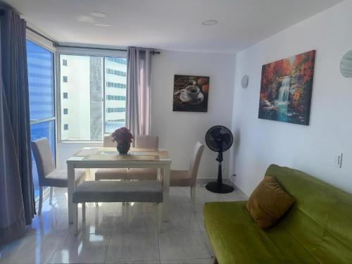 a living room with a table and a green couch at Cartagena Sotavento Laguito in Cartagena de Indias