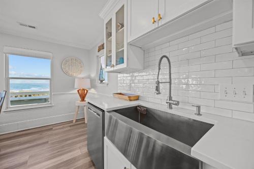 a kitchen with a sink and a window at Oceanfront luxury, private pool & beach access! in Holden Beach
