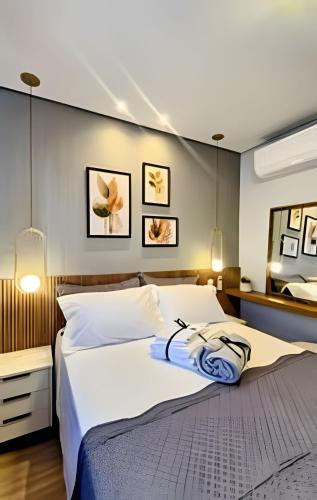 a bedroom with a large white bed and a mirror at Apto 2/4 com Wi-Fi, TV, piscina e garagem | 1402 in Campinas
