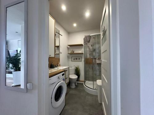 a bathroom with a washing machine and a toilet at Mazury Witaj in Ostróda