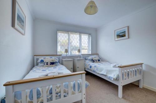 a bedroom with two beds and a window at 2 Bed in Croyde oc-sandc in Croyde