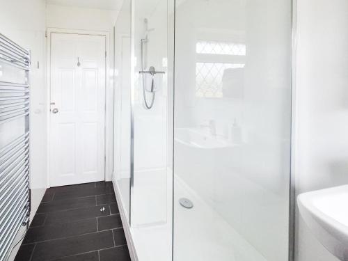 a white bathroom with a shower and a sink at 2 Bed in Croyde oc-sandc in Croyde