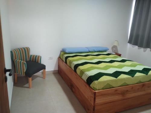 a bedroom with a bed and a chair at Departamento 2 ambientes complejo Marlu in Federación