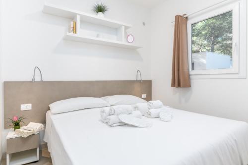 a bedroom with a white bed with towels on it at Ostuni Torre Pozzelle Open Air in Ostuni Costa Merlata