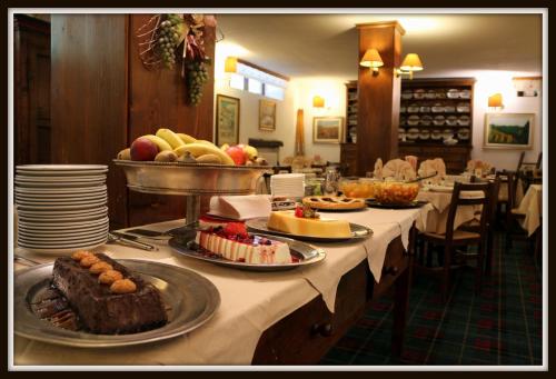 a table with several plates of food on it at Hotel La Quiete in Bardonecchia