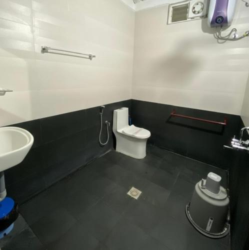 a bathroom with a white toilet and a sink at Thulir Farm Stay Near Isha Yoga Adiyogi in Coimbatore