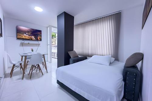 a bedroom with a bed and a table with chairs at hermoso apartasuite con la mejor ubicación in Cartago