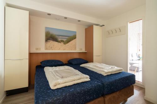 a bedroom with a bed with two pillows on it at Appartement De Jutter, Resort Amelander Kaap in Hollum