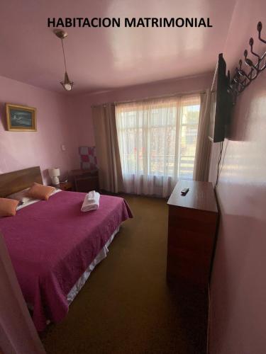 a bedroom with a purple bed and a window at Hospedaje Rios in Osorno