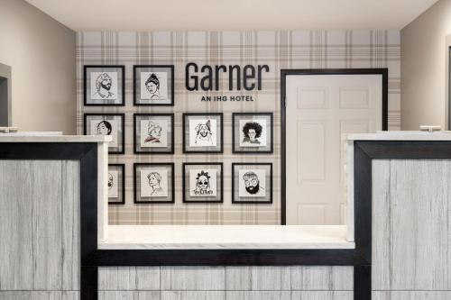a gallery of framed pictures on a wall in a room at Garner Hotel Albuquerque Airport by IHG in Albuquerque