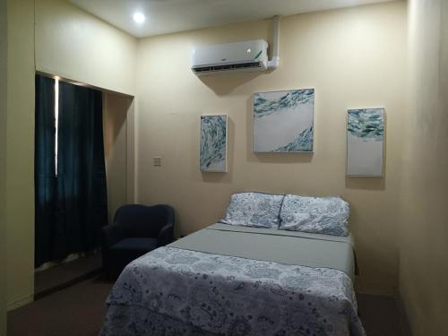 una camera da letto con un letto, una sedia e dei quadri di Cozy Kingston Flat a Kingston