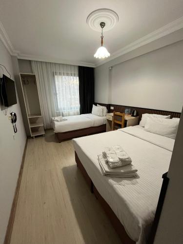 a hotel room with two beds and a television at Balkan Palace Edirne in Edirne