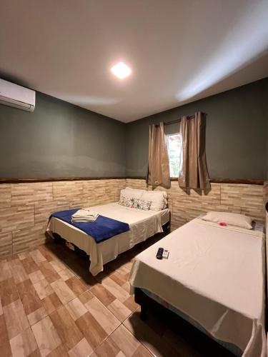 a bedroom with two beds and a window at Mangut in São Miguel dos Milagres