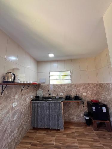 a kitchen with a sink and a counter in a room at Mangut in São Miguel dos Milagres