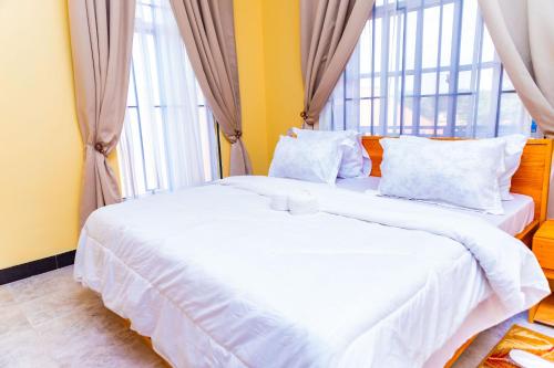 two beds in a room with two large windows at Grace villa in Zame