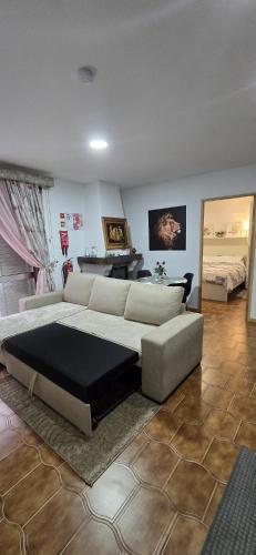 a bedroom with a large bed and a couch at Moradia Belo horizonte in Alfena