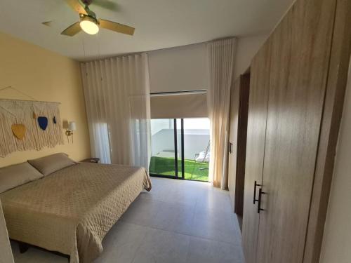 a bedroom with a bed and a sliding glass door at Turquesa depa in Cabo San Lucas