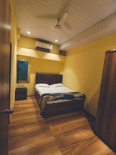 a bedroom with a bed and a flat screen tv at Villa 04 in Mumbai