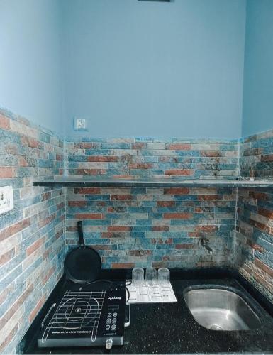 a kitchen with a brick wall next to a sink at Villa 04 in Mumbai