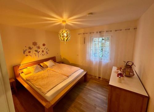 a bedroom with a bed and a window and a chandelier at Autumn Apartment in Gerbrunn