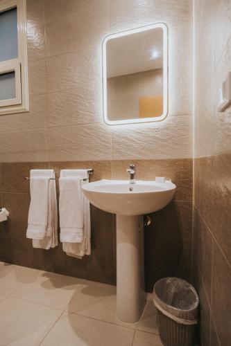 a bathroom with a sink and a mirror and towels at The View Luxor hotel in Luxor