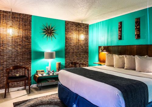 a hotel room with a bed and a green wall at Roadrunner Lodge Motel in Tucumcari