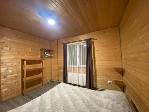 a bedroom with a bed in a wooden room at Шпінь 2 in Vorokhta