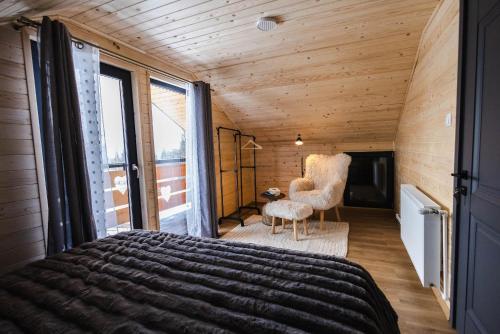 a bedroom with a large bed and a chair at Cabana Almora in Dorna Arini