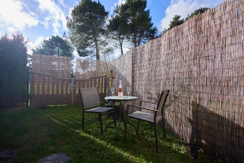 a table and two chairs next to a fence at Studio cosy - Jacuzzi inclus - À 5 min du Mans in Mulsanne