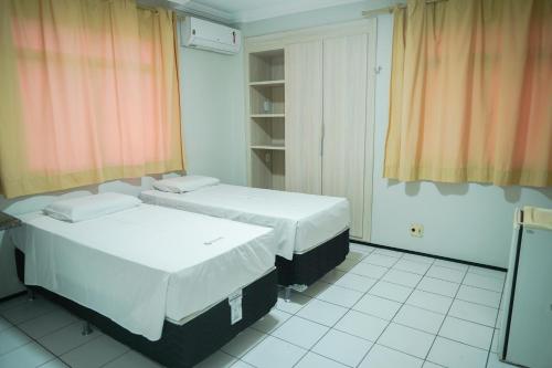 zwei Betten stehen in einem Zimmer mit in der Unterkunft Hotel Visconde in Sobral