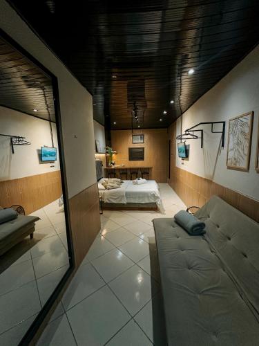 a living room with a couch and a bed at Espaços Cardoso, GRÊS - refúgio sólido e silencioso in Igrejinha