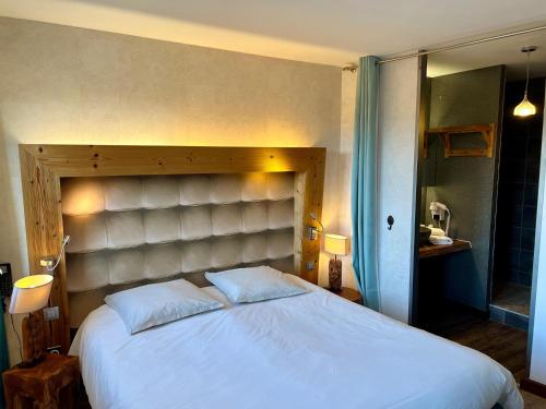 a bedroom with a large white bed in a room at Logis Hôtel - Auberge les Clarines in Le Châtelard