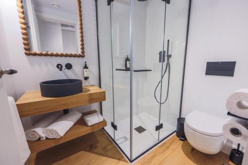 a bathroom with a glass shower and a sink at Do Bico Rooms in Camariñas