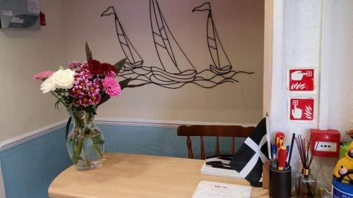 a vase of flowers sitting on a table at The Trelinda Guest House in Newquay