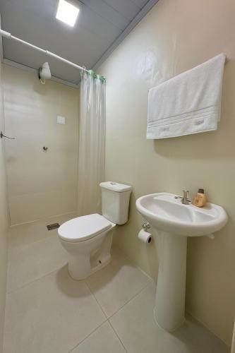 a white bathroom with a toilet and a sink at Hotel COP 30 in Belém