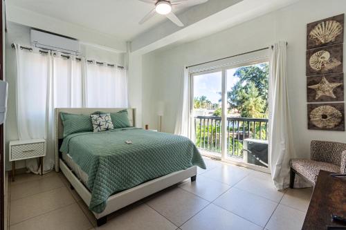 a bedroom with a bed and a balcony at Novus Mare, Cabarete center! in Cabarete