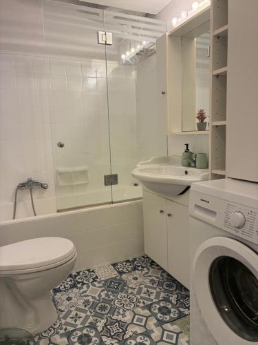 a bathroom with a toilet and a sink and a washing machine at Corfu SKYLINE RESIDENT 360 in Corfu