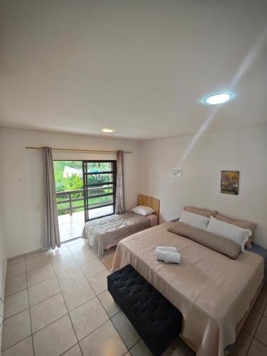 a bedroom with two beds and a balcony at Park Golf Hostel Ipelandia in Foz do Iguaçu