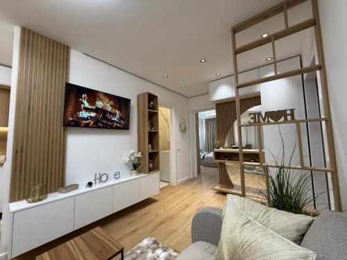 a living room with a couch and a tv on a wall at Luxury Residence in Baia Mare