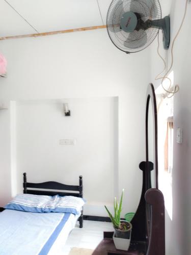 a bedroom with a bed and a fan at Vinal Inn Midigama in Midigama East