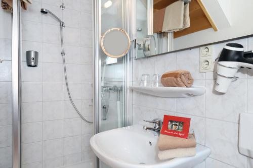 a white bathroom with a sink and a shower at Bauerncafé Sprengel in Bad Gandersheim