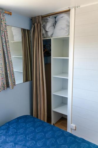 a bedroom with a bed and a closet with shelves at Louisiana in Anloo