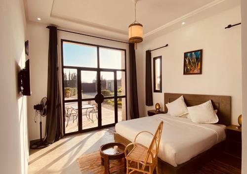 a bedroom with a bed and a large window at Dar Ayman Essaouira in Essaouira